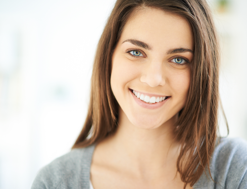 Happy young woman looking at camera with smile.